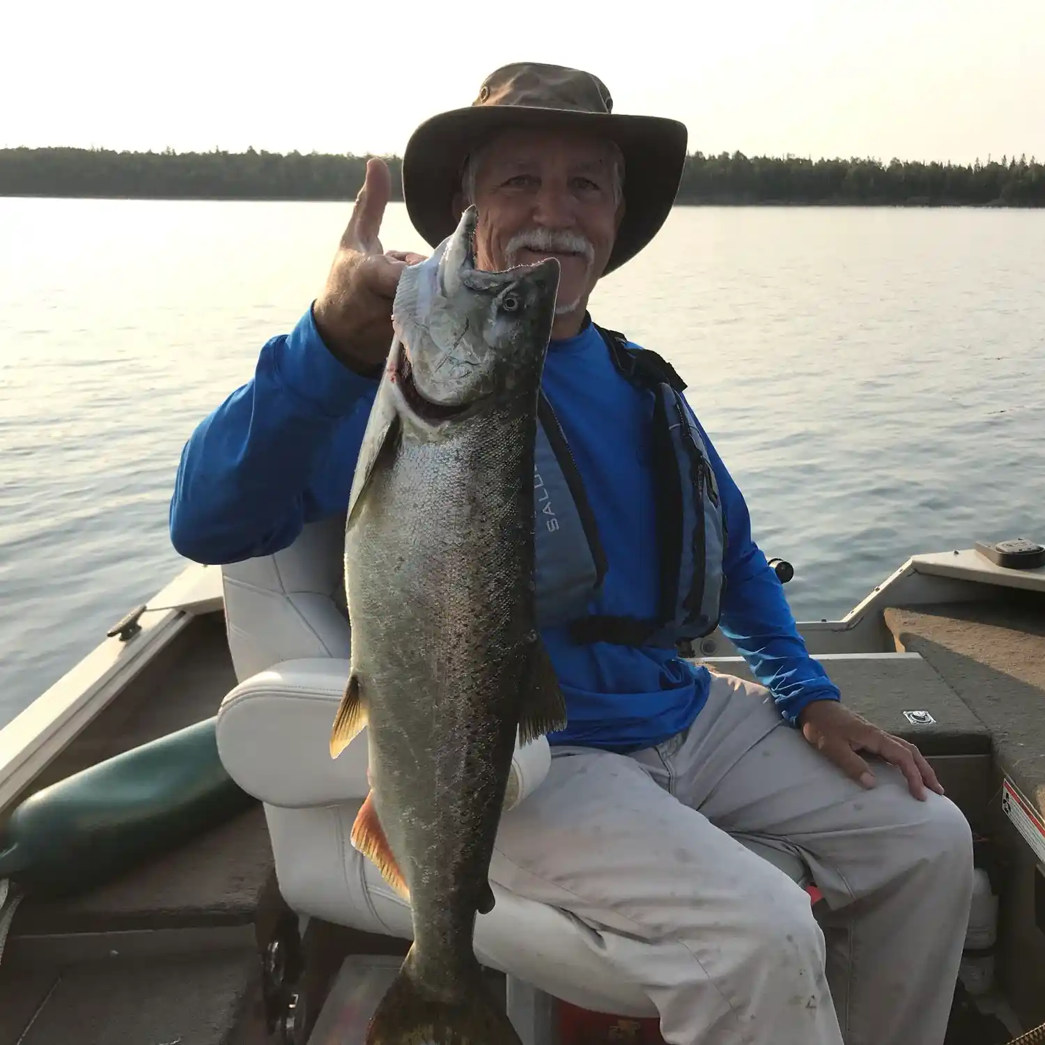 A man sitting in a boat on a lake. Fishing trip fishing canada